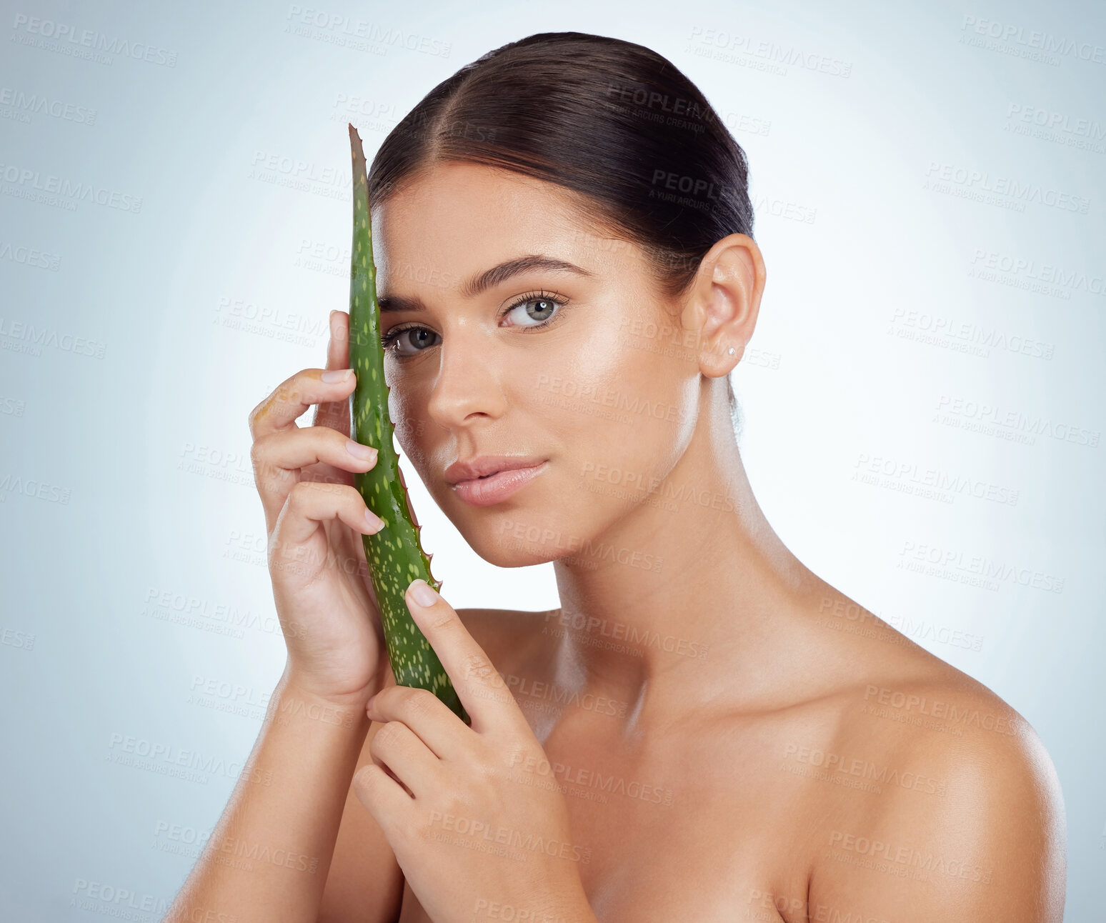 Buy stock photo Portrait of beautiful woman holding aloe vera leaf for skincare routine. Caucasian model isolated against grey studio background and posing with copyspace. Organic plants for hydration and moisture