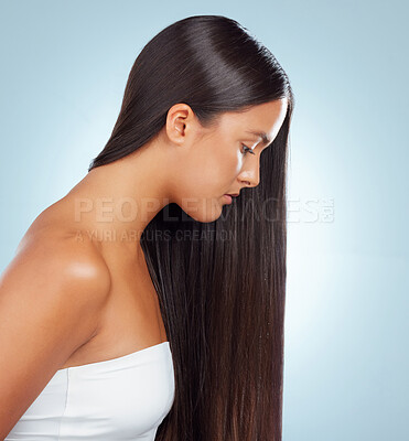 Buy stock photo A hispanic brunette woman with long lush beautiful hair posing and looking serious against a grey studio background. Mixed race female standing showing her beautiful healthy hair