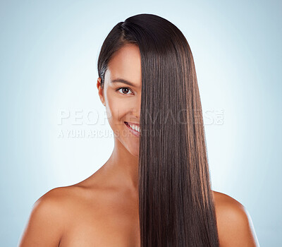 Buy stock photo Portrait of a hispanic brunette woman with long lush beautiful hair smiling and posing against a grey studio background. Mixed race female standing showing her beautiful healthy hair