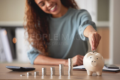 Young african american woman money putting coins into a piggybank at home. Mixed race person counting coins while financial planning in her living room. Saving, investing and thinking about the future