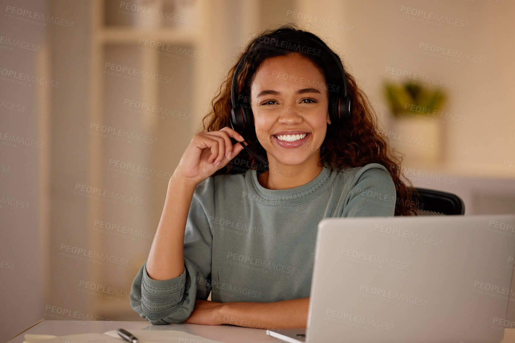 Buy stock photo One young woman using headset and working late on a laptop in an office. Happy woman doing freelance work as a call centre agent. Consultant operating a helpdesk for customer care, sales and support