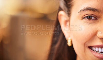 Closeup portrait of a young mixed race woman smiling and looking happy with a nose piercing, half faced. Cropped close up of a hispanic females face in the foreground against a blurred background. Smile a while and give your face a rest