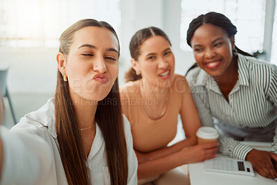 Buy stock photo Portrait of a confident young hispanic business woman making a funny face expression while taking selfies with her colleagues in an office. Group of three happy smiling women taking photos as a dedicated and ambitious team in a creative startup agency