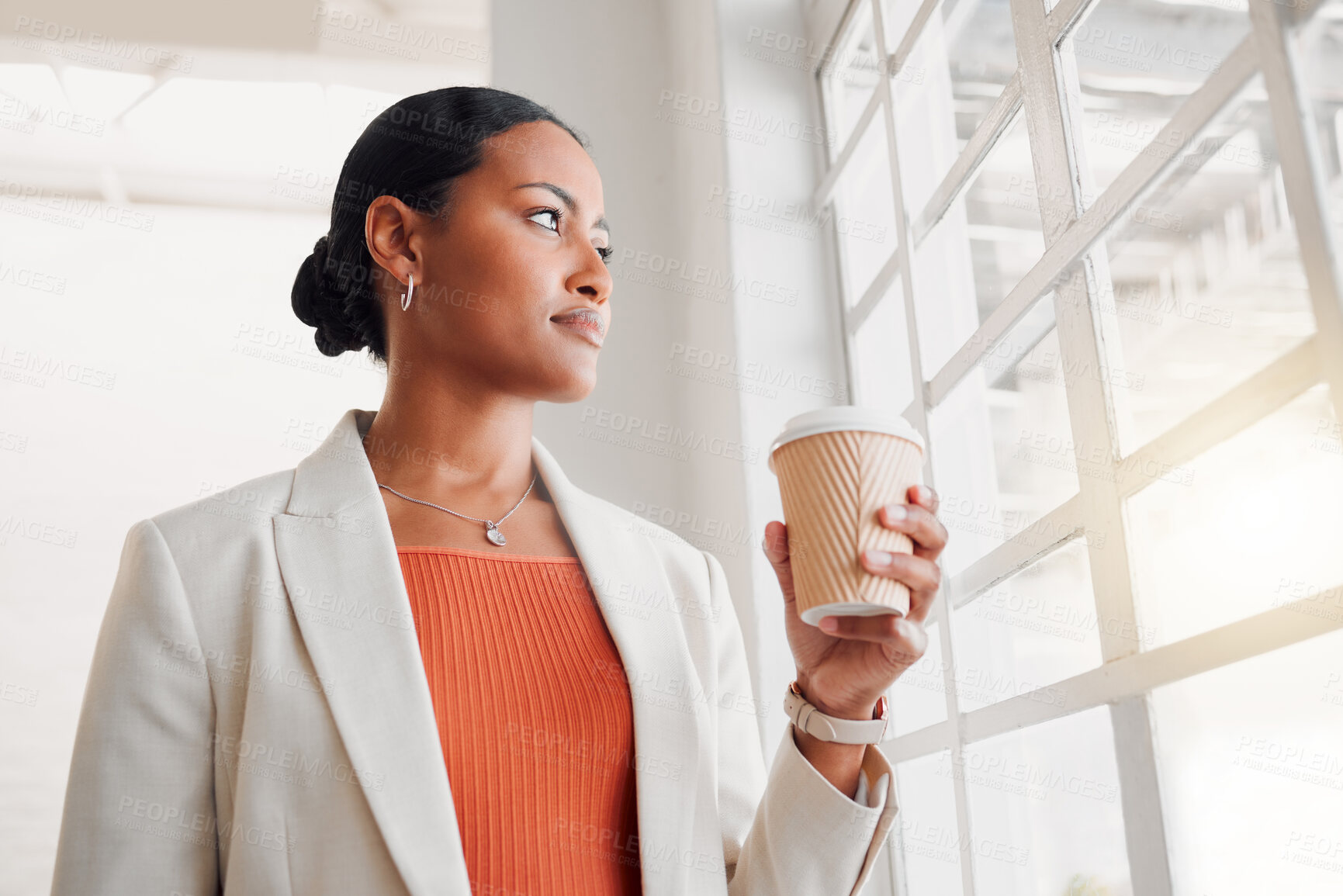 Buy stock photo Young mixed race businesswoman looking out of a window while drinking a coffee alone in an office at work. Confident hispanic businessperson looking out of a window drinking a coffee on a break while standing at work