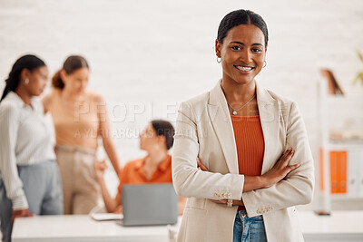 Young happy mixed race businesswoman standing with her arms crossed in an office at work. Confident hispanic businessperson standing in a meeting at work