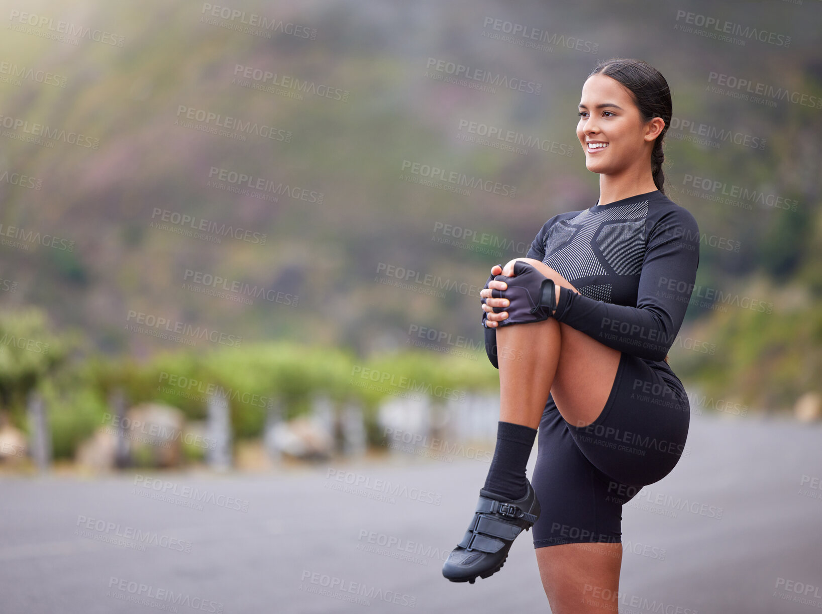 Buy stock photo Active and fit young mixed race woman stretching her leg during outdoor exercise. Smiling, toned hispanic athlete getting ready to run in the morning. Routine sports and physical activity are healthy