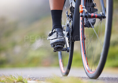 Buy stock photo Closeup of one woman cycling outside. Sporty fit female athlete with her feet on bicycle pedals while riding a bike on a road for exercise. Endurance and cardio during a workout and training
