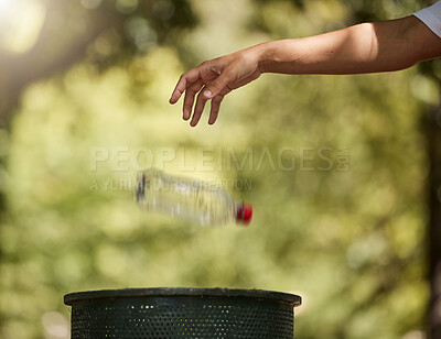 Closeup shot of a woman throwing an empty water bottle into a bin outside. Recycling is important. Saying goodbye to litter and cleaning up our planet. Protect the environment and save the earth