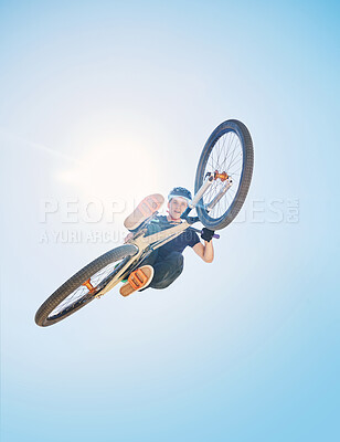 Buy stock photo Man showing his cycling skills while out cycling on a bicycle outside. Adrenaline junkie practicing a dirt jump outdoors. Male wearing a helmet doing tricks with a bike. Hovering, passionate and free