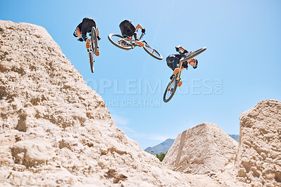 Buy stock photo Young man showing his cycling skills while out cycling on a bicycle outside. Adrenaline junkie practicing a dirt jump outdoors. Wearing a helmet doing tricks with a bike. Extreme sports on a mountain 