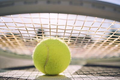 Buy stock photo Closeup view of a tennis ball and tennis racket on a court in a sports club during the day. Playing tennis is exercise, promotes health, wellness and fitness. Macro view of tennis gear and equipment