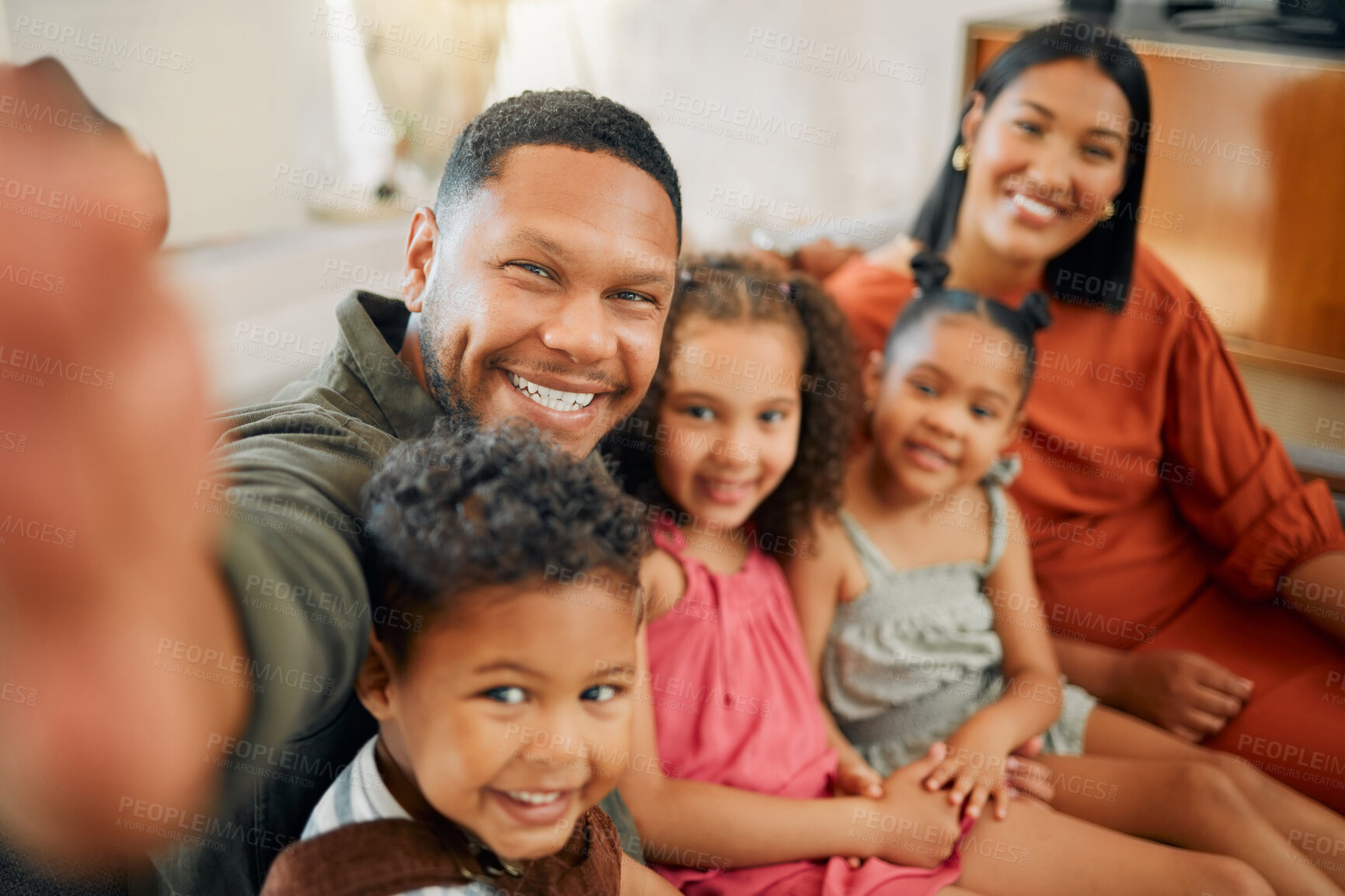 Buy stock photo Portrait of a mixed race family of five relaxing on the sofa at home. Loving black family taking a selfie on the sofa. Young couple bonding with their adopted kids at home