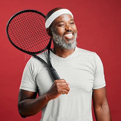 Buy stock photo One happy mature african american man standing against a red background in studio and posing with a tennis racquet. Smiling black man feeling fit and sporty while playing a match. Ready for the court