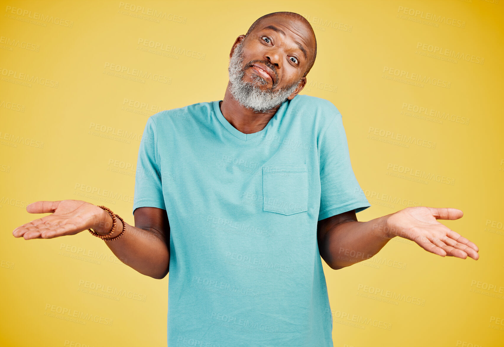 Buy stock photo Portrait of a mature african american man smiling and making a gesture of not knowing something while smiling against a yellow studio background. Black african man looking quirky. Sometimes you don't know what surprises might be waiting for you