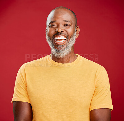 Mature african american man with a beard standing and smiling against a red studio background. Happy, positive, carefree. Laughing, cheerful, joy