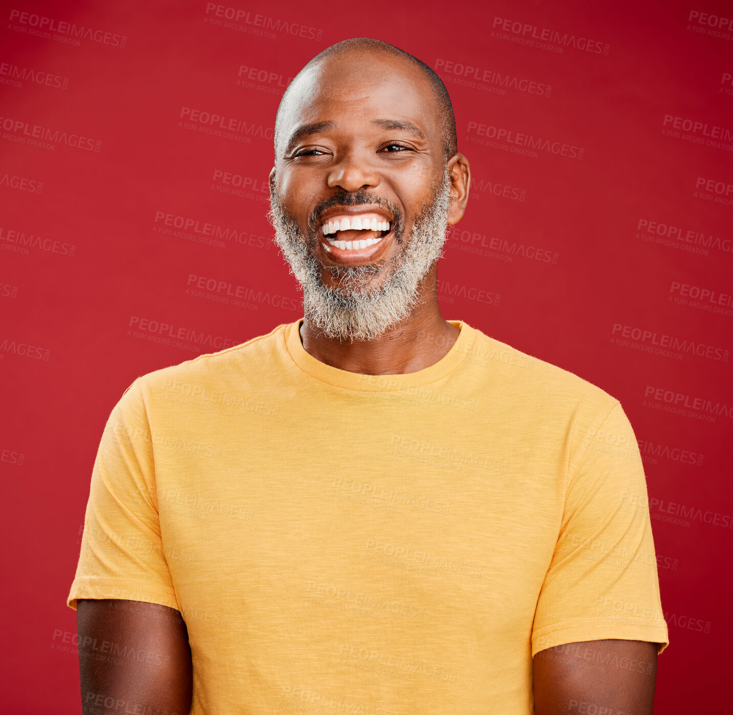 Buy stock photo Mature african american man with a beard standing and smiling against a red studio background. Happy, positive, carefree. Laughing, cheerful, joy