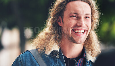 Buy stock photo A cheerful handsome man with curly hair in the park. A happy young man laughing relaxing outside in the park. A young handsome man with blonde curly hair spending time in the garden