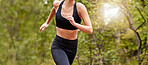 Close up of a woman's fit body wearing workout clothes while out for a run at a park or in nature on a sunny day. Woman exercising and living a healthy lifestyle