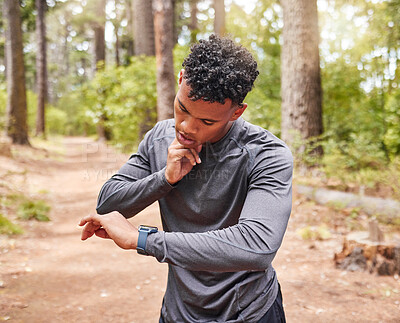 Buy stock photo African American man checking his pulse while wearing a smartwatch and tracking his pulse, heartbeat and cardio health. Athlete using a device to keep track of his vitals while out jogging in a park 