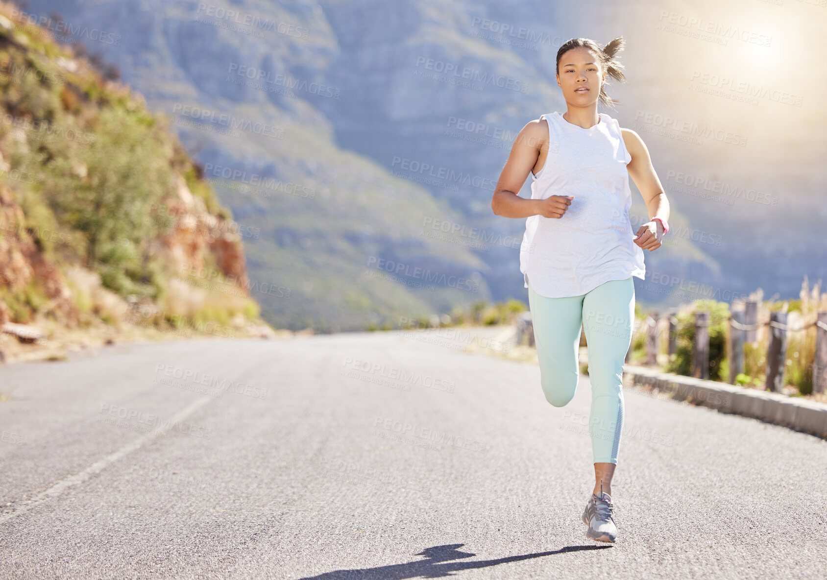 Buy stock photo Young mixed race hispanic female athlete running outside in nature on the road. Exercise is good for your health and wellbeing. Running in the morning. Enjoying, relaxing, positive
