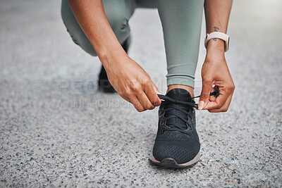 Buy stock photo Unrecognizable woman tying her shoelaces before a run outside in the city on a road. Exercise is good for health and wellbeing. Getting ready, prepare
