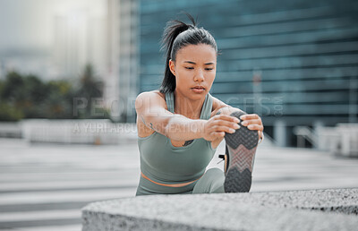 Buy stock photo Sporty young hispanic female athlete stretching her legs before a run outside . Fit young woman warming up while exercising in the city. Exercise is good for your health and wellbeing