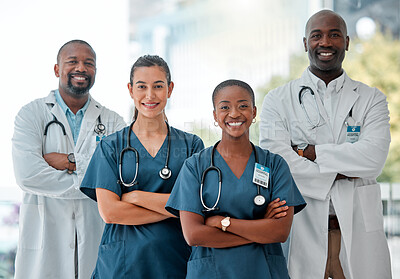 Buy stock photo Group of happy doctors and nurses standing in a line with their arms crossed while working at a hospital. Content expert medical professionals smiling at work together at a clinic