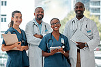 Group of doctors and nurses standing in a line with their arms crossed while working at a hospital. Content expert medical professionals smiling at work together at a clinic