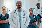 Group of happy diverse doctors standing together while working at a hospital. Content expert medical professionals smiling at work together at a clinic