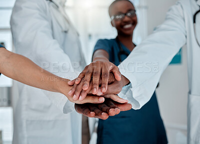 Buy stock photo Group of diverse doctors stacking their hands together in support while working at a hospital. Medical professionals joining their hands in unity and motivation while working at a clinic