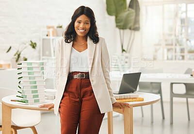African american businesswoman leaning on her desk. Portrait of a young businesswoman in her office. Creative designer working in her agency. Powerful businesswoman standing in her architecture agency