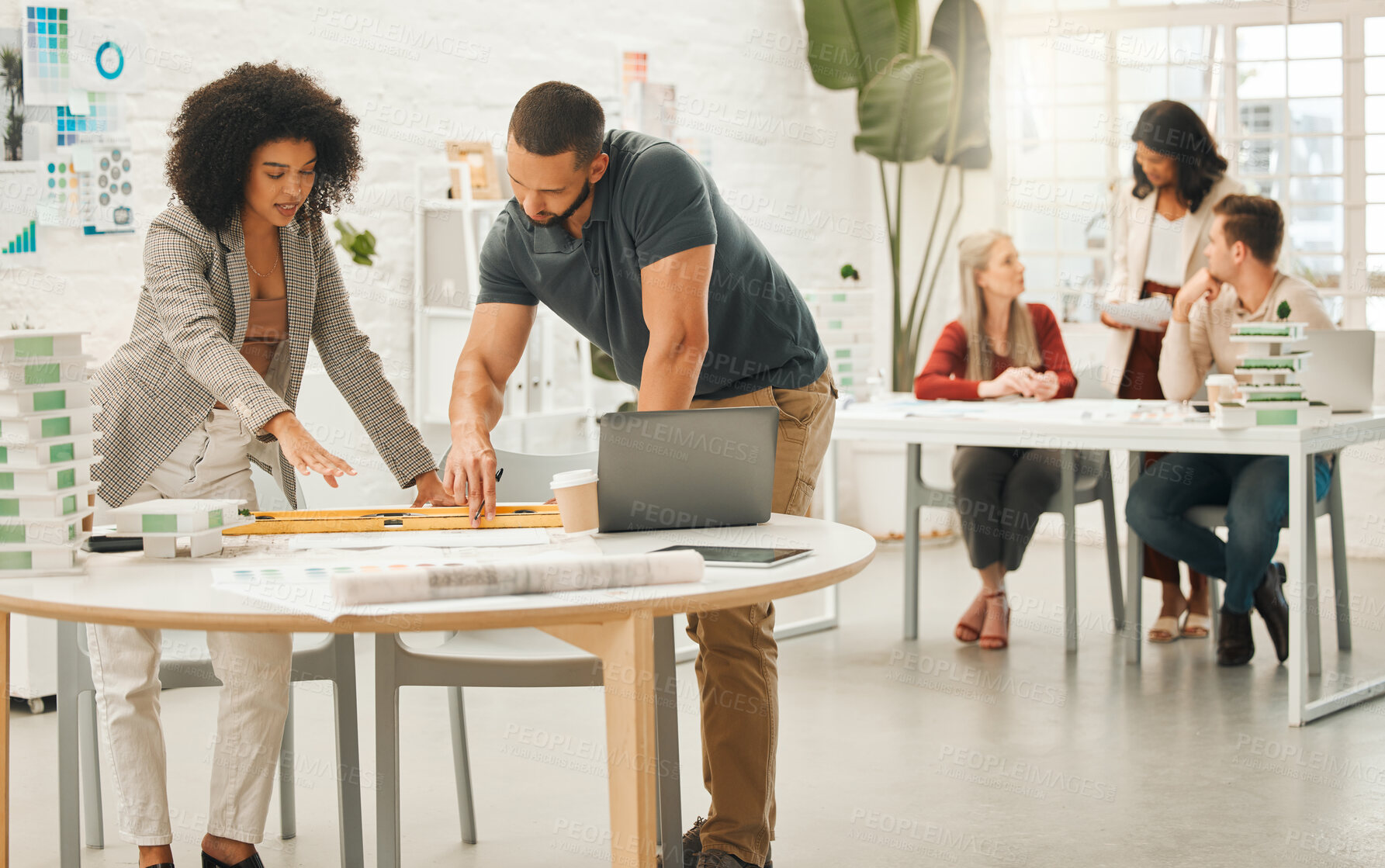 Buy stock photo Diverse businesspeople working together. Team of architects working in an office together. Businesspeople collaborate on a building project. Coworkers collaborate in architectural agency