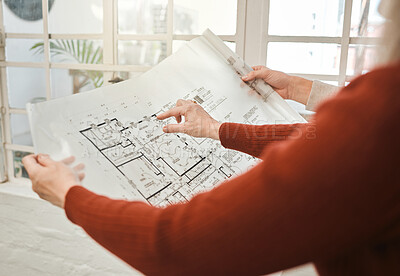 Hands of businesspeople holding a blueprint. Closeup of architect holding a building plan. Two colleagues collaborate on building project. Engineers collaborate on building blueprint.