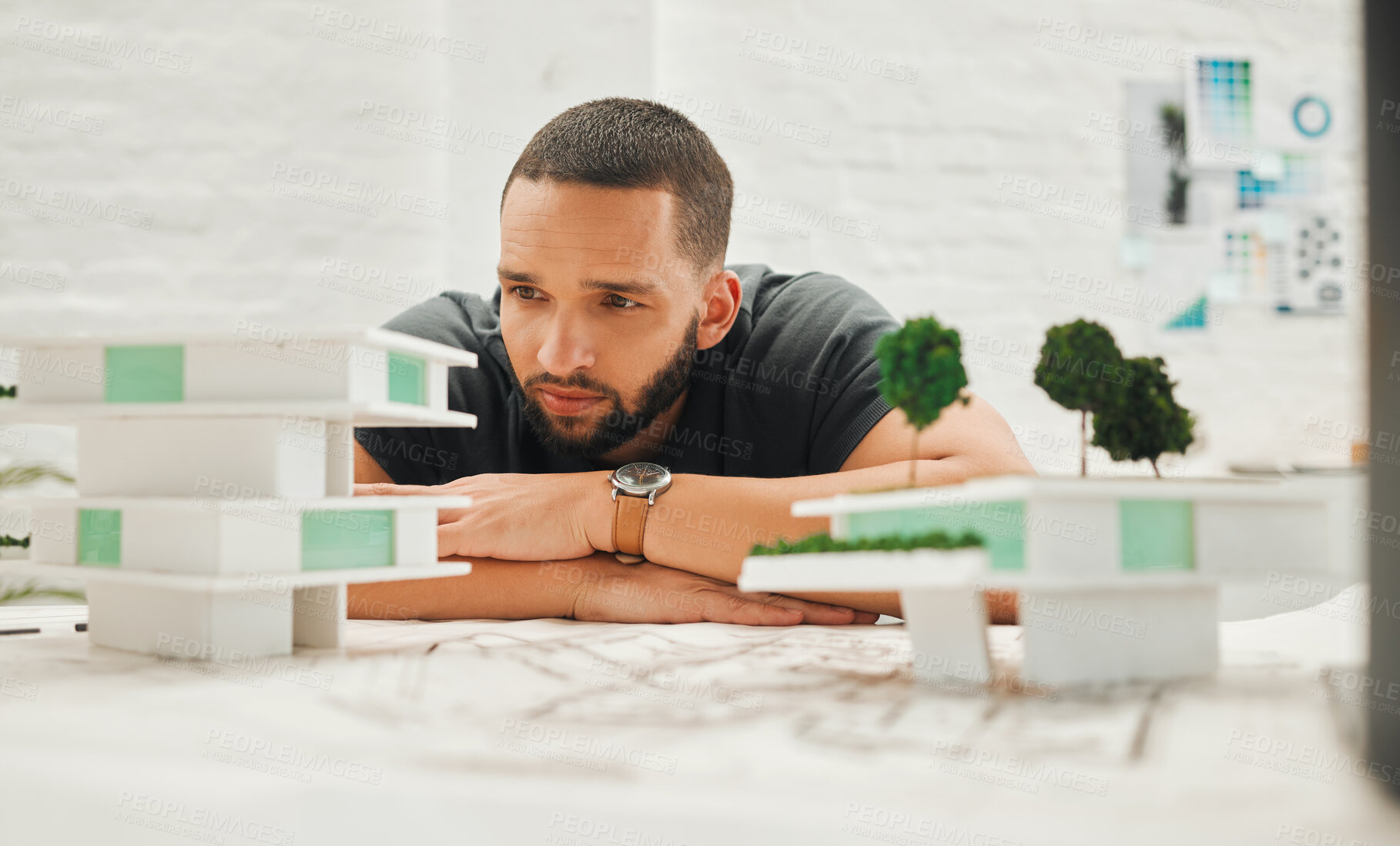 Buy stock photo Focused architect looking at building model. Young businessman thinking about a building model. Handsome engineer working on a 3D building model. Engineer working on a 3D model