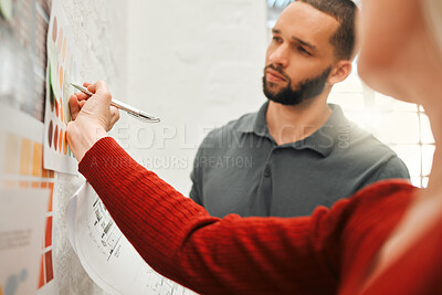 Buy stock photo Businesspeople brainstorm together. Businesswoman writing her ideas down. Serious businessman collaborating with colleague. Businessperson writing ideas on a sticky note.