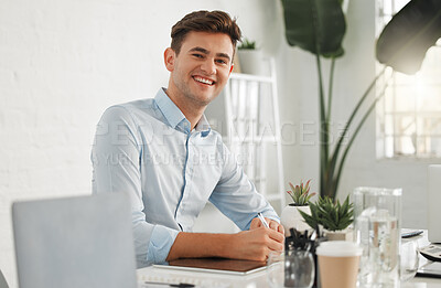 Portrait of a young caucasian businessman writing in a notebook at work. One happy businessperson making a note in a diary while working in an office