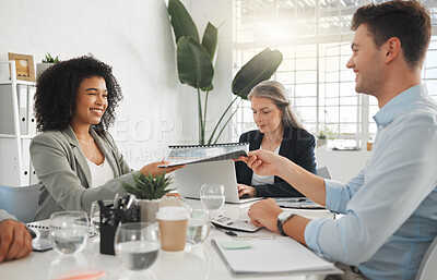 Young happy mixed race businesswoman giving a report to a male caucasian colleague while in a meeting together at work. Businessman taking a document from an hispanic female colleague