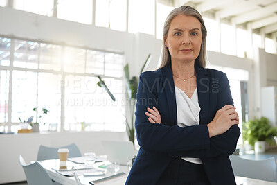 Buy stock photo Mature focused caucasian businesswoman standing with her arms crossed while in an office alone. One confident female manager standing at work