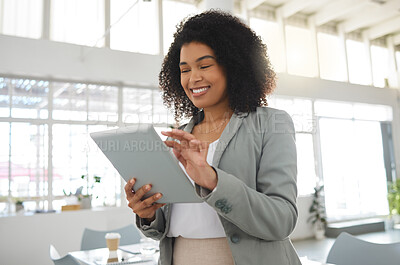 Buy stock photo Young happy mixed race businesswoman working on a digital tablet in an office. One cheerful hispanic female boss with a curly afro holding and using social media on a digital tablet at work
