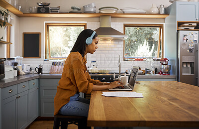 Buy stock photo Home, remote work and business woman on laptop for research project, strategy and planning in kitchen. Freelancer, focus and girl with headphones for music with documents, computer and working online