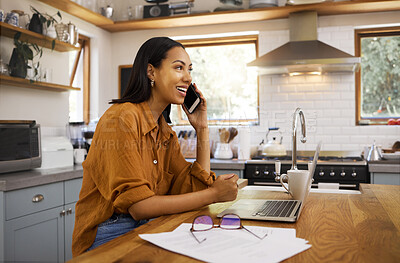 Young cheerful mixed race businesswoman going through paper and bills while on a call using her phone and working on a laptop at home. One hispanic female businessperson using a laptop and talking on a phone while banking at home