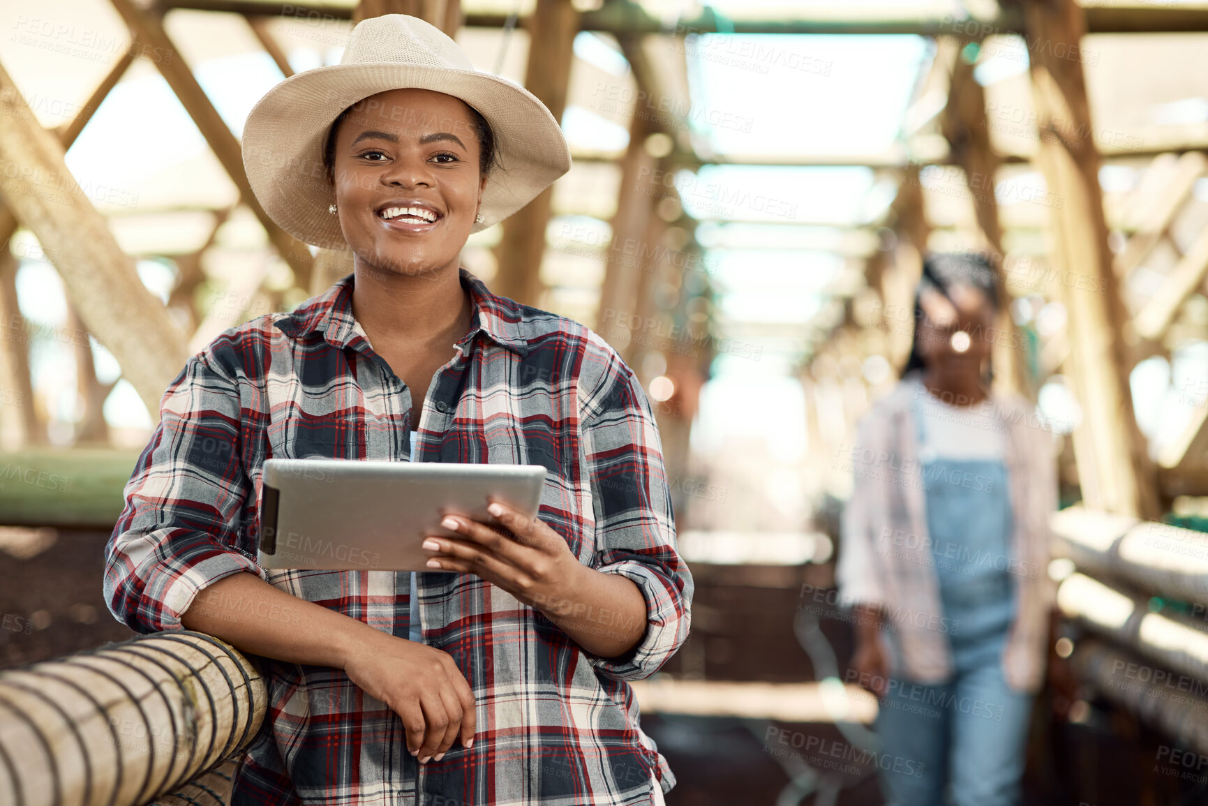 Buy stock photo Happy farmer using a digital tablet. African american farmer using a digital device. Portrait of a smiling farmer standing in a greenhouse. farm worker holding wireless tech device.