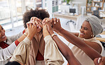 Diverse group of smiling ethnic business women holding hands after brainstorm meeting in office. Ambitious happy confident professional team of colleagues celebrating a success and feeling empowered