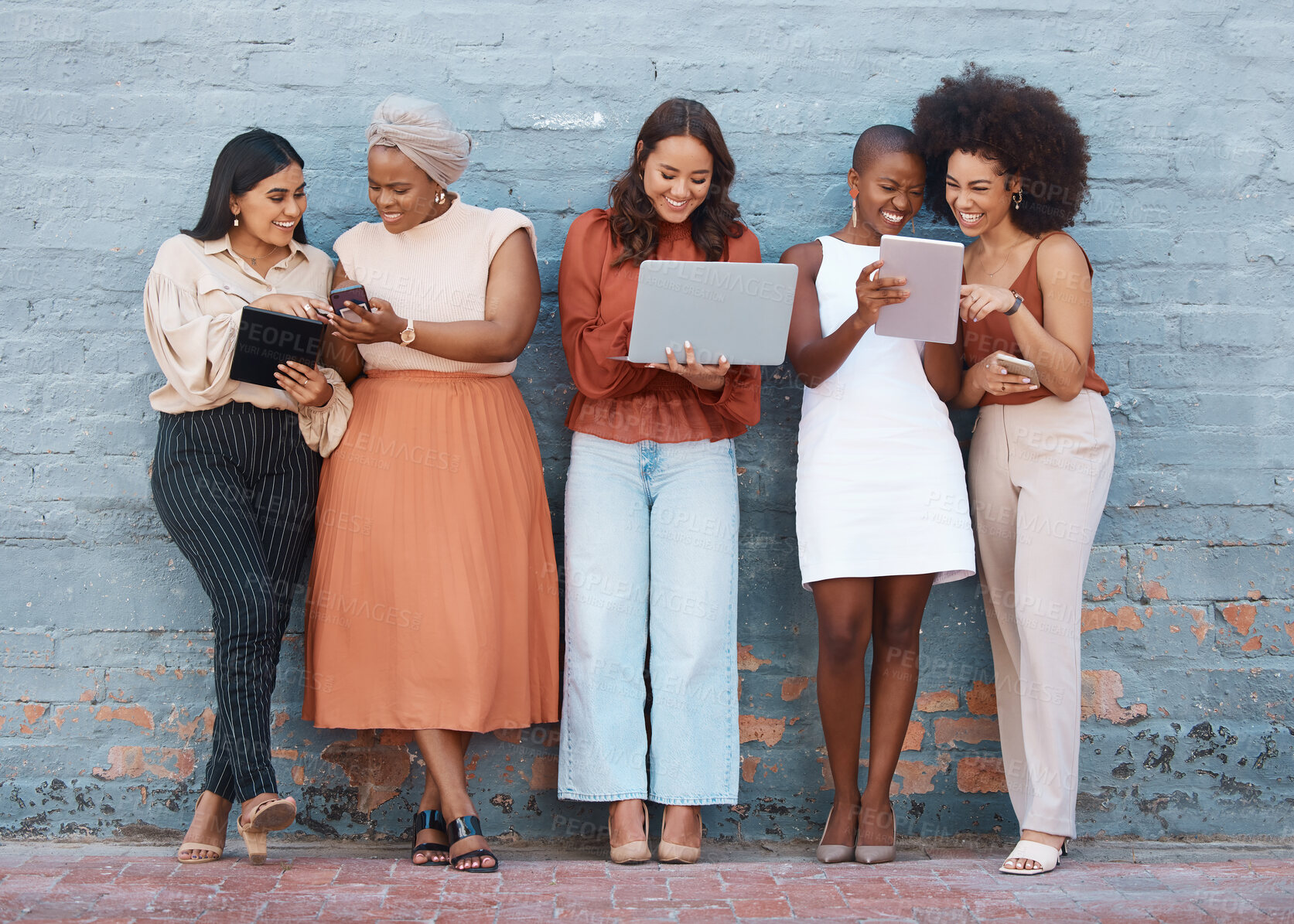 Buy stock photo Happy, talking and women on a brick wall with tech for communication, social network and advice. Team, diversity and group of female employees speaking while using technology in the city for work