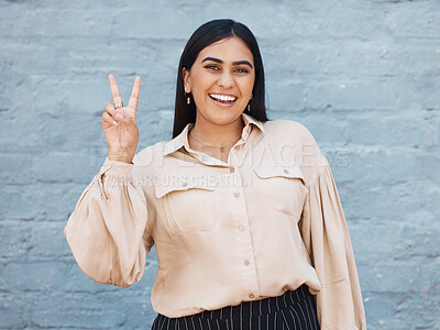 Buy stock photo Happy woman, portrait smile and peace sign in business against a gray wall background. Excited and friendly female face smiling showing peaceful hand emoji, sign or gesture with positive attitude