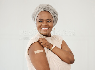 Buy stock photo Black woman, smile and covid plaster on arm in studio for injection with medical insurance. Portrait of African female happy on a white background with vaccine, safety compliance and mockup space