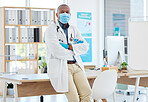 Proud african american doctor arms crossed. Medical professional wearing a mask to protect from covid. Doctor keeping safe from corona in his office. portrait of confident physician in his office