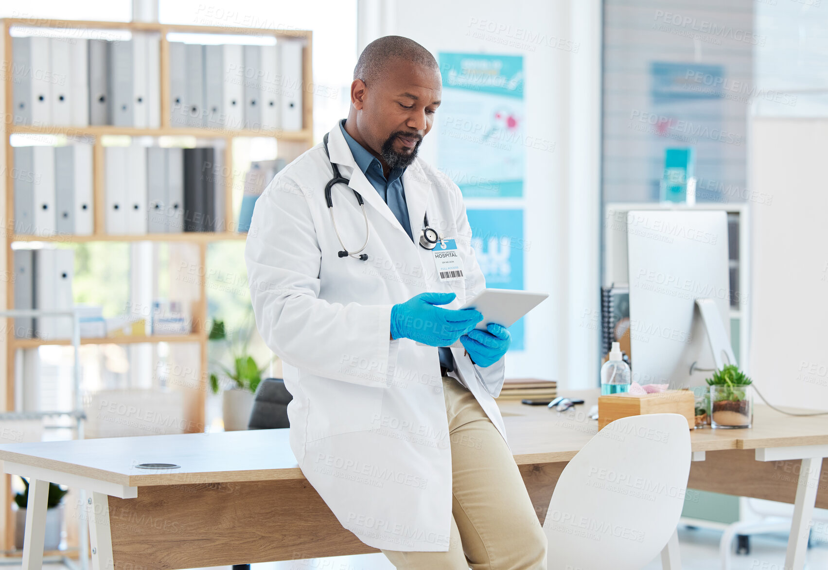 Buy stock photo Black man, doctor and tablet in healthcare research, planning or checking schedule appointment at hospital. Happy African male medical professional working and browsing on touchscreen for Telehealth