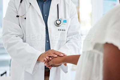 Closeup on doctor holding a patients hand. African american doctor being kind to a patient cropped. Doctor offering a patient caring support. Doctor and patient in a consult together