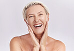 Portrait of a happy smiling mature caucasian woman looking positive and cheerful while posing topless in a studio against purple copyspace background. Older woman doing her skincare routine